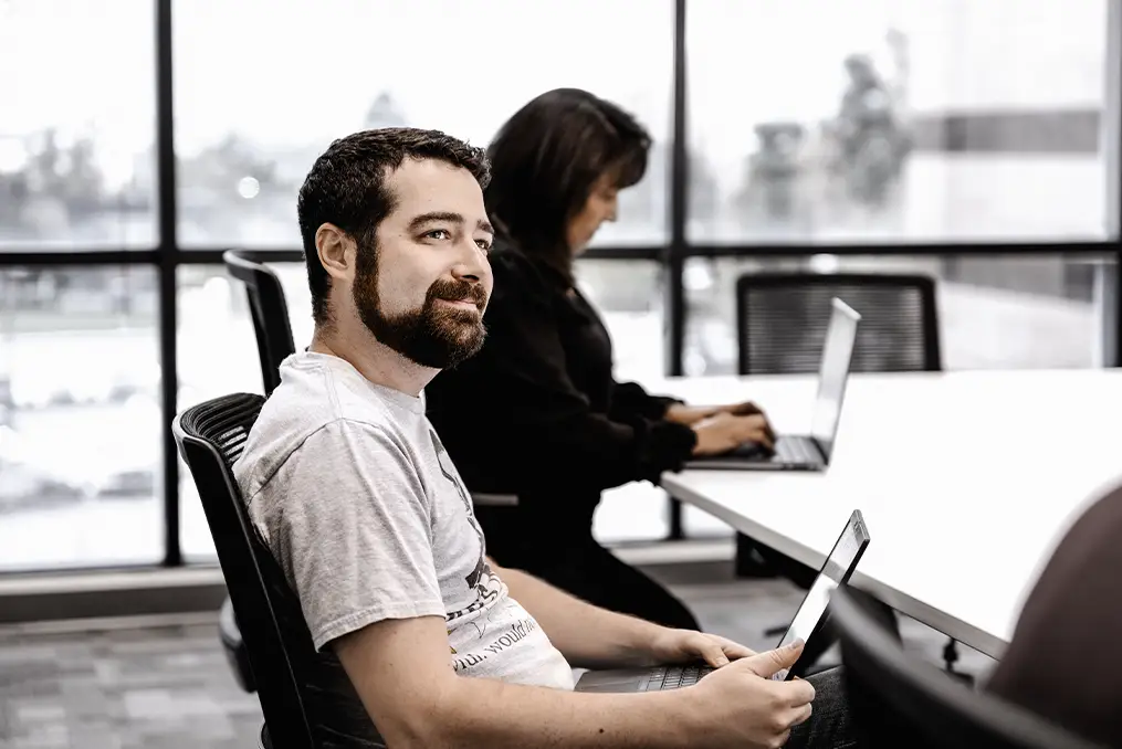 A man sits at a desk with a laptop